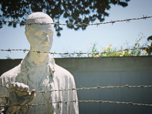 Why Does Power Corrupt? - Weekly Blog Post by Dr. Craig Biehl - statue of man behind barbed wire in a concentration camp