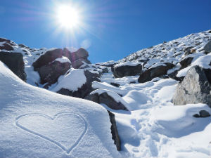 To Know Him Is to Love Him - Weekly Blog Post by Dr. Craig Biehl - snowy mountainside in bring sun, heart drawn on snow bank