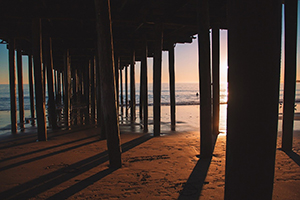 Presuppositions of Faith (3 of 6): The Presumption of Omniscience - pier pylons facing sunset on beach