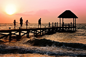 Presuppositions of Faith (4 of 6): Are Miracles Reasonable? - 2 parents and 2 children walking on a pier at sunset